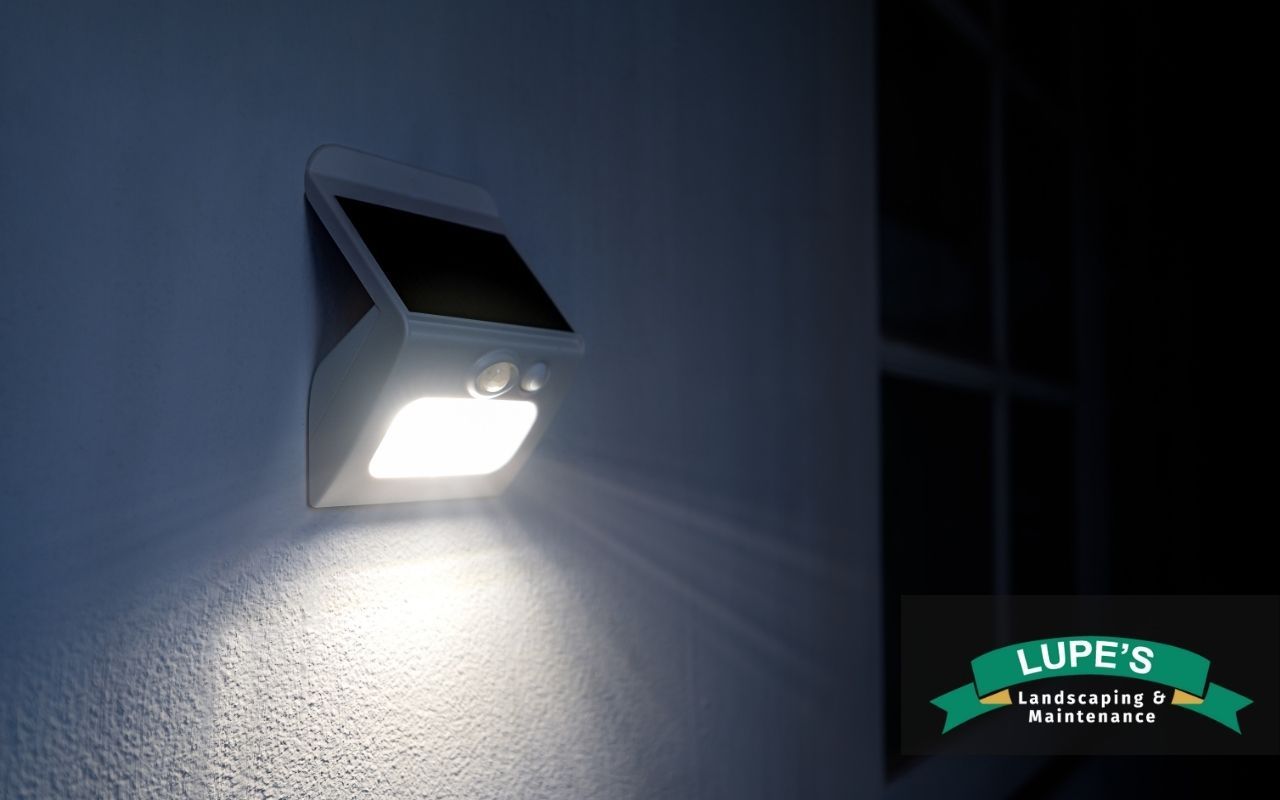 Motion sensor spotlight positioned in a landscaped garden bed