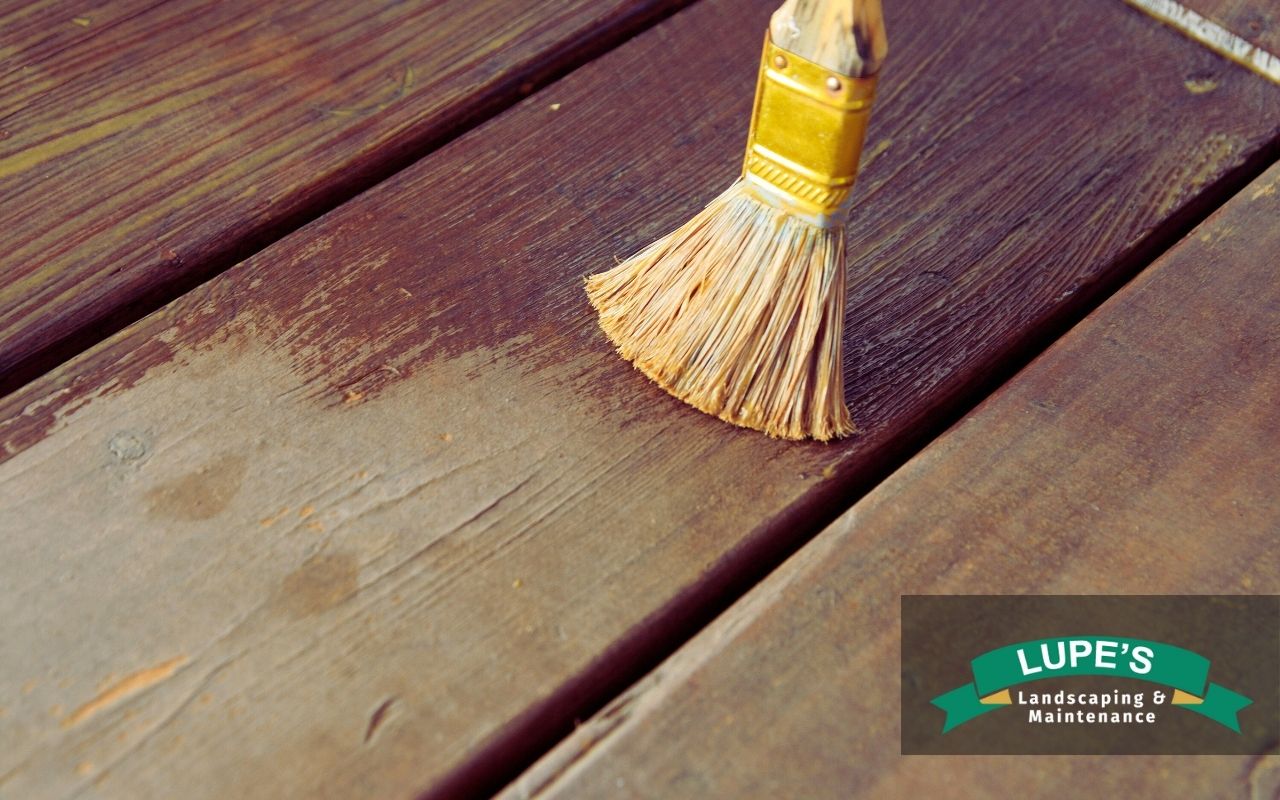 Homeowner applying waterproof sealant in Bainbridge Island, following expert deck waterproofing tips to prevent water damage.